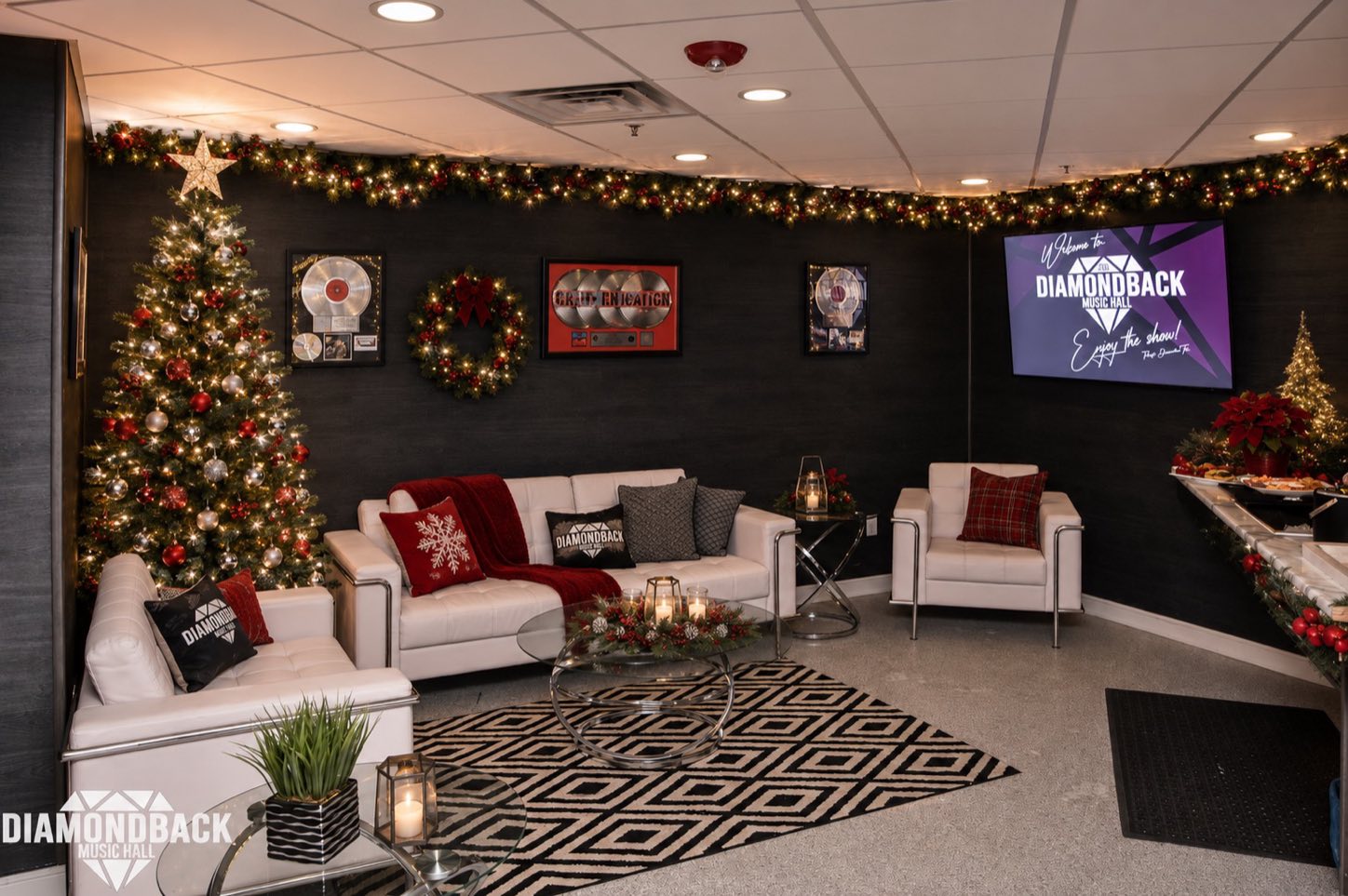 The green room lounge decorated for the holidays — sofas, a Christmas tree and gold records