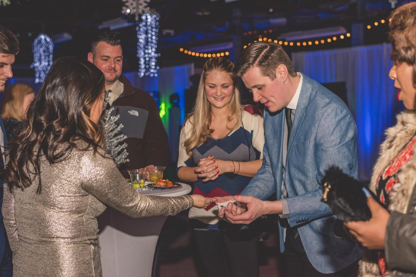 A live close-up magician performing a card trick for guests at Diamondback Music Hall
