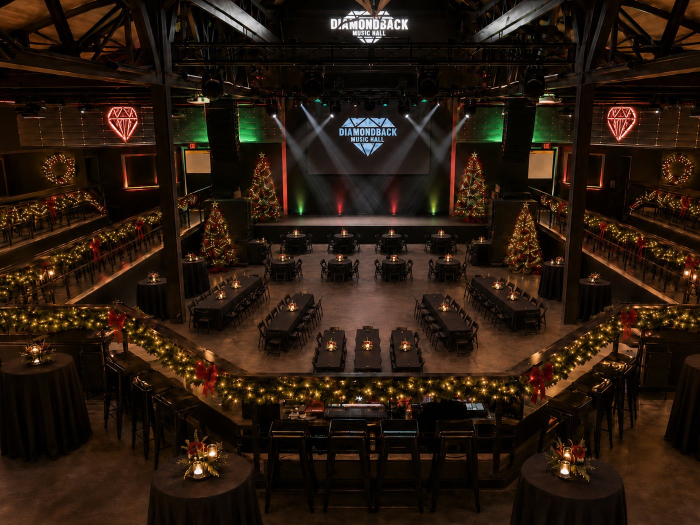 The Diamondback main floor set for Deck the Halls — rounds and long banquet tables ringing an open dance floor in front of the stage