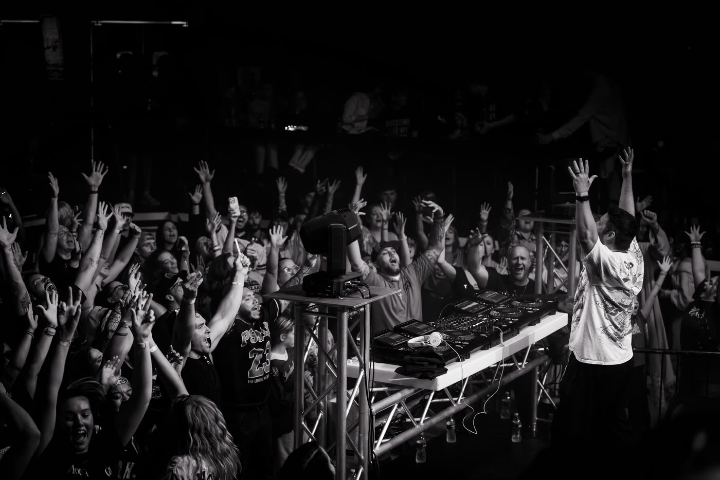 Crowd with hands raised at the front rail