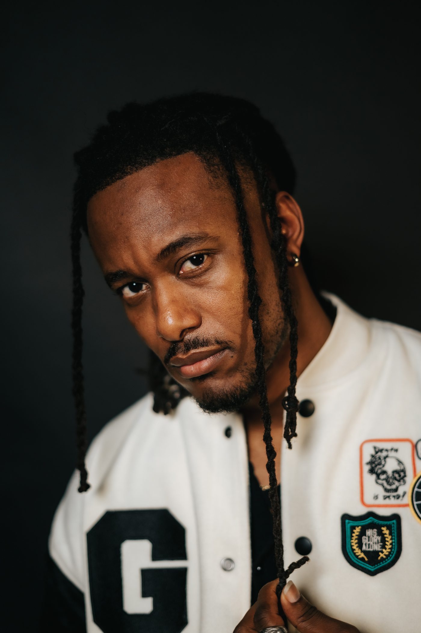 KB press portrait in a varsity jacket