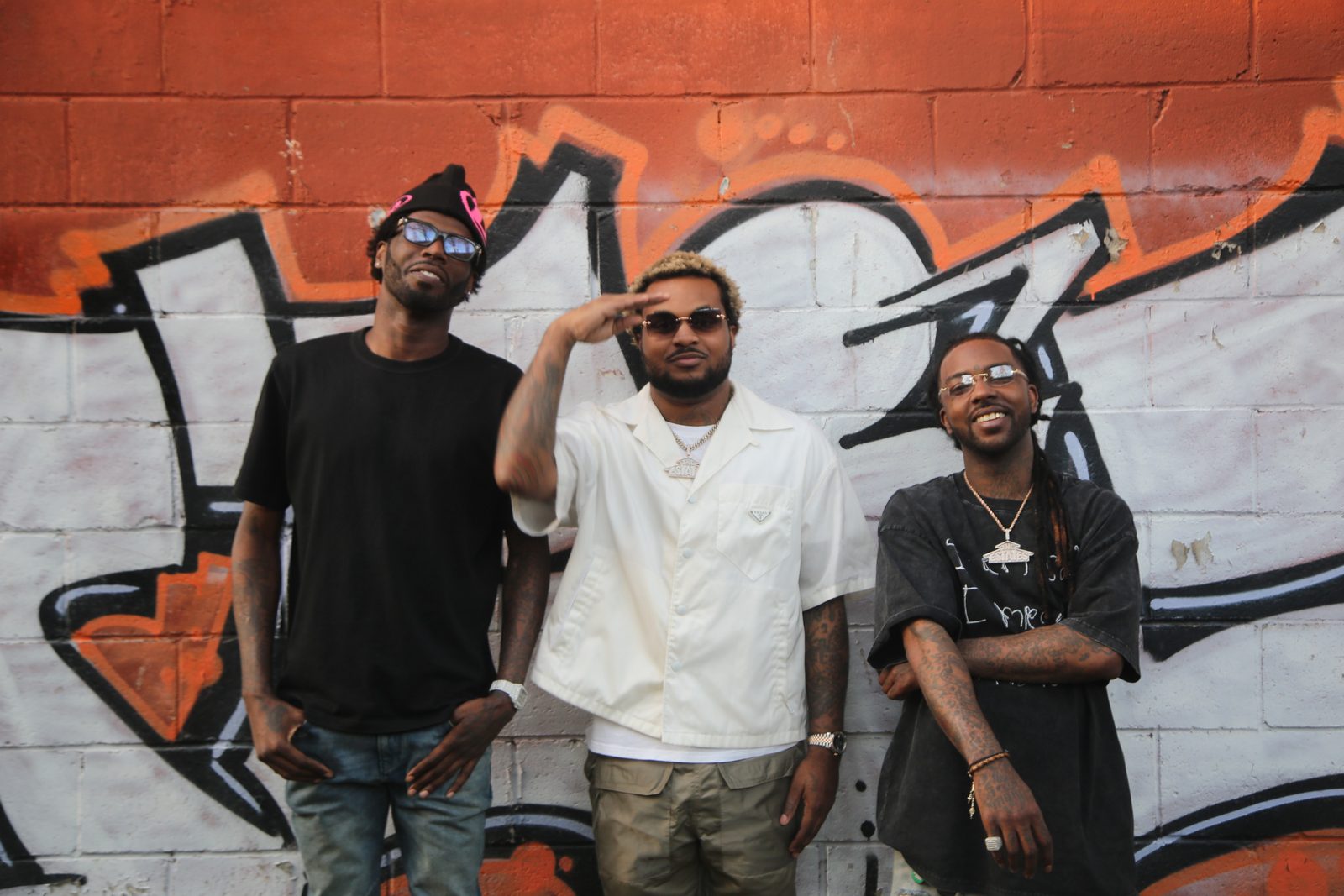 Travis Porter, Ali, Quez and Strap, in front of a graffiti wall