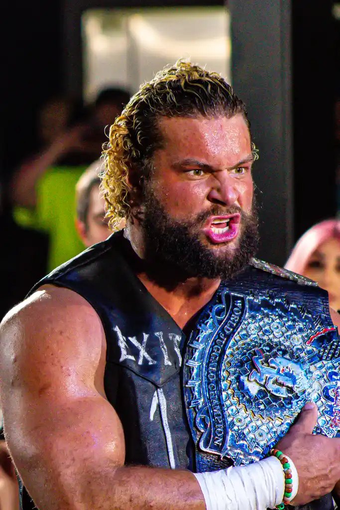 Champion with the title belt on his shoulder