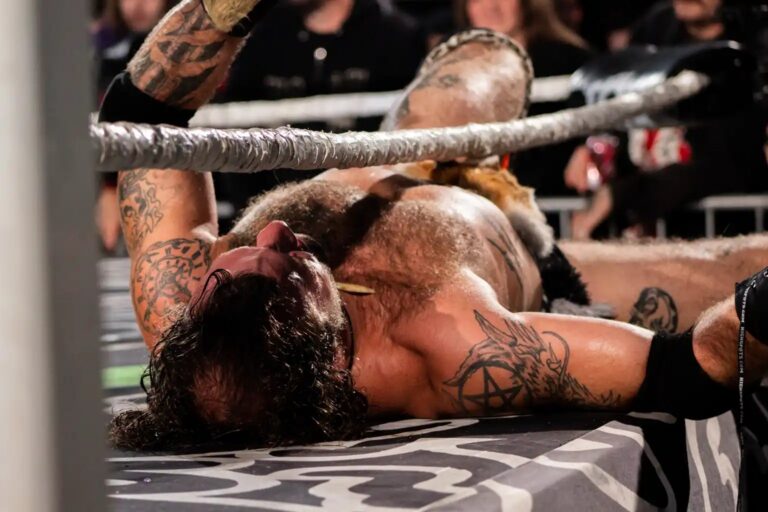 Wrestler down on the mat after a big hit