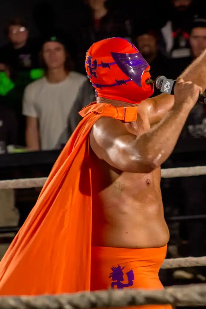 Masked luchador in an orange cape